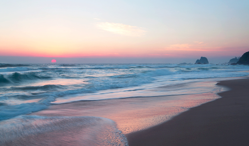 Beautiful pastel pink sunrise over surf beach Narooma