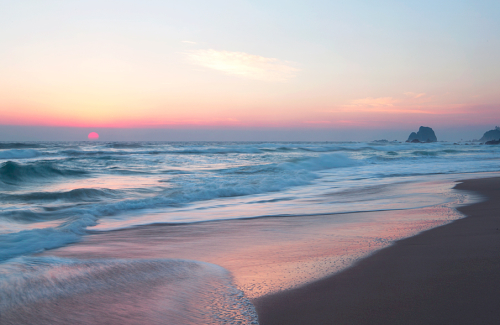 Beautiful pastel pink sunrise over surf beach Narooma