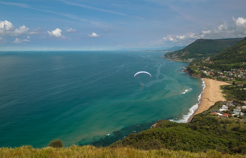 Parachuters jump from Bald Hill to land on the beach. Stanwell Gardens, Stanwell tops, Wollongong, NSW, Australia